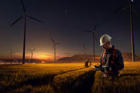 Happy engineer feel success after good work. He standing and looking beautiful sunset landscapeの写真素材