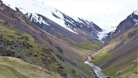 View of mountains with snowfall and stream