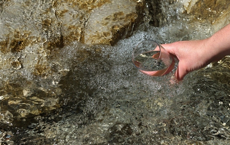 Beautiful woman hands holding a glass of waterの写真素材