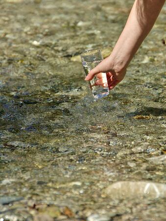 Beautiful woman hands holding a glass of waterの写真素材