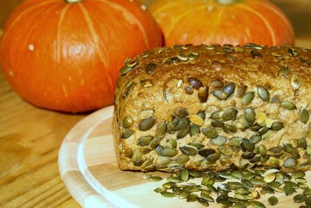Pumpkin seed bread with grains on a breadboardの写真素材