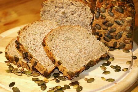 Pumpkin seed bread with grains on a breadboardの写真素材