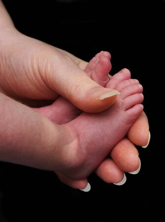 Baby feet in mothers handの写真素材