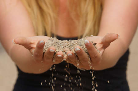 Sand melts away by beautiful woman handsの写真素材