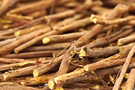 Licorice root sticks lie on a wooden tableの写真素材