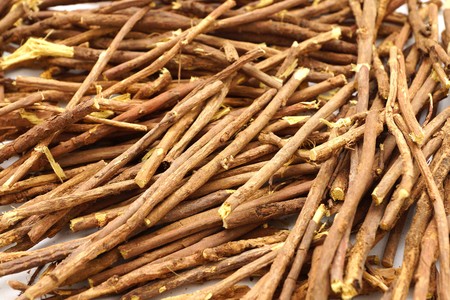 Licorice root sticks lie on a wooden table