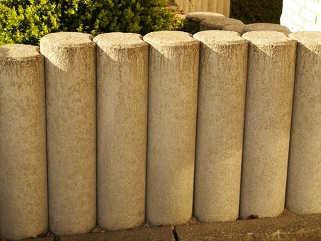 Picket fence of stone in front of a house