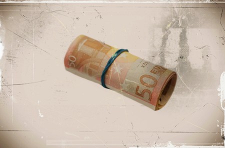 A roll with fifty euro banknotes on sepia backgroundの写真素材