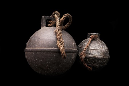 Two old fishing net metal balls on black backgroundの写真素材