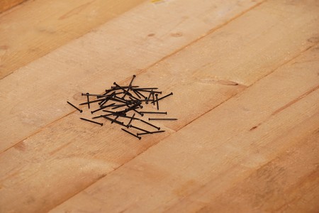 Steel nails on a wooden floorの写真素材