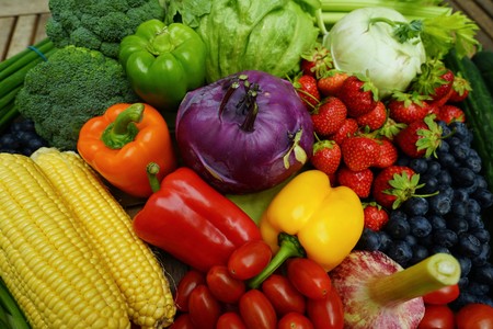 Fresh organic fruits and vegetables on a wooden tableの写真素材