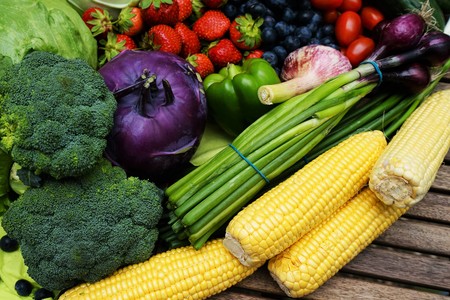 Fresh organic fruits and vegetables on a wooden tableの写真素材