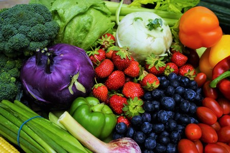 Fresh organic fruits and vegetables on a wooden tableの写真素材