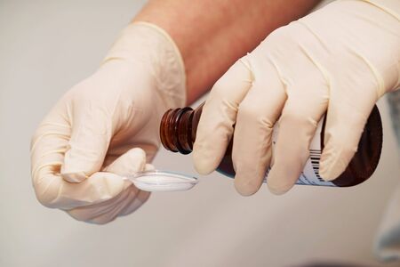 Doctor gives an antibiotic on a plastic spoon