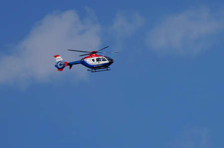 Police helicopter under a blue sky in summerの写真素材