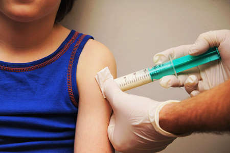 Doctor gives an injection to a little boyの写真素材