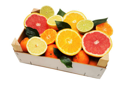Healthy tropical citrus fruits in a wooden box on white backgroundの写真素材