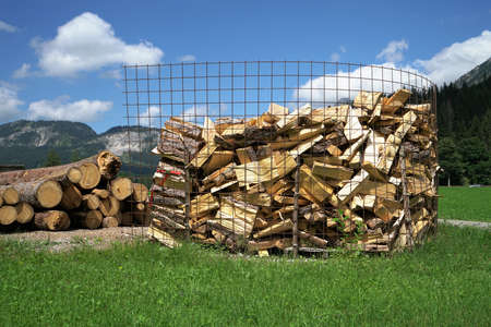 A large amount of firewood under a blue skyの写真素材
