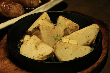 Closeup of grilled potato on hot fry panの写真素材