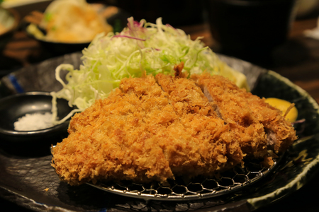 Tonkatsu, Japanese deep-fried pork cutlet, with sliced cabbage on a plateの写真素材