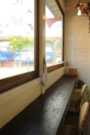 Wooden counter and chairs by the window in small cafe in Japanの写真素材