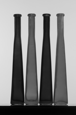 Thin designer bottles aligned on a wooden boardの写真素材