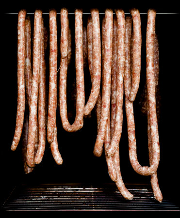 Some sausage hanging in a smokehouse waiting to be smoked.の写真素材