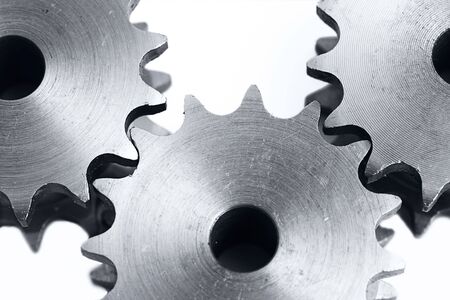 three metal cogs on a white backgroundの写真素材