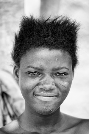 PORTO-NOVO, BENIN - MAR 8, 2012: Unidentified Beninese smiling woman with stylish hair. People of Benin suffer of poverty due to the difficult economic situation.のeditorial素材