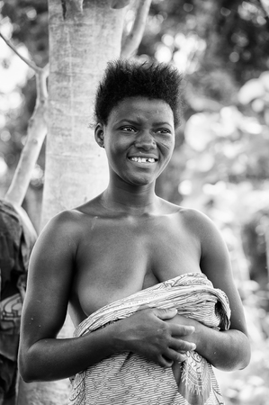 PORTO-NOVO, BENIN - MAR 8, 2012: Unidentified Beninese lwoman smiles with a stylish hair. People of Benin suffer of poverty due to the difficult economic situation.のeditorial素材