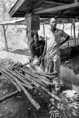 PORTO-NOVO, BENIN - MAR 8, 2012: Unidentified Beninese man cooks on the wood. People of Benin suffer of poverty due to the difficult economic situation.のeditorial素材