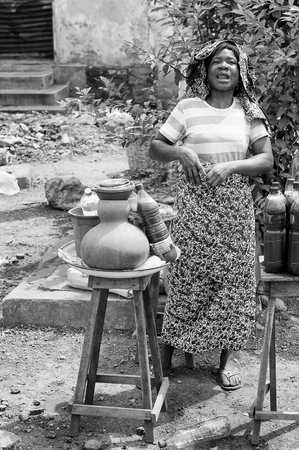 PORTO-NOVO, BENIN - MAR 8, 2012: Unidentified Beninese woman sells souvenirs to the tourists. People of Benin suffer of poverty due to the difficult economic situation.のeditorial素材