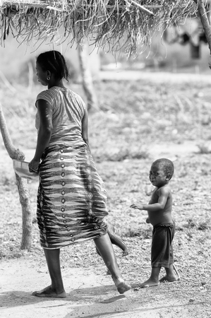 PORTO-NOVO, BENIN - MAR 8, 2012: Unidentified Beninese woman plays with her children. People of Benin suffer of poverty due to the difficult economic situation.のeditorial素材