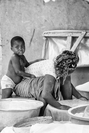 BENIN, MARCH 8, 2012: Unidentified Beninese boy plays with his mother in Benin, Mar 8, 2012. People of Benin suffer of poverty due to the unstable economical situationのeditorial素材