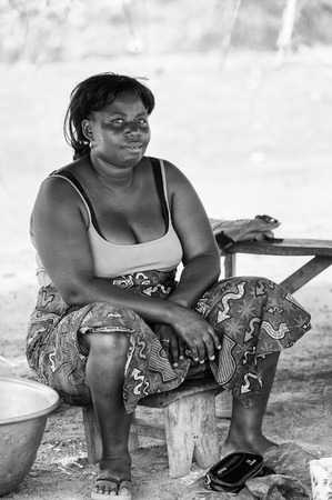 PORTO-NOVO, BENIN - MAR 8, 2012: Unidentified Beninese fat woman works at the market. People of Benin suffer of poverty due to the difficult economic situation.のeditorial素材
