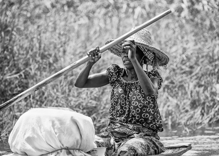 PORTO-NOVO, BENIN - MAR 9, 2012: Unidentified Beninese woman rows a wooden boat.People of Benin suffer of poverty due to the difficult economic situationのeditorial素材