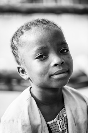 PORTO-NOVO, BENIN - MAR 8, 2012: Unidentified Beninese girl looks peacefully on the camera. People of Benin suffer of poverty due to the difficult economic situation.のeditorial素材