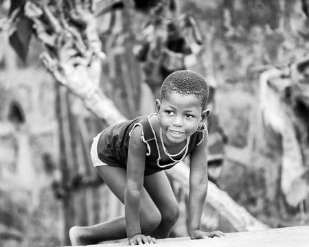PORTO-NOVO, BENIN - MAR 9, 2012: Unidentified Beninese little girl plays outdoor. Children of Benin suffer of poverty due to the difficult economic situationのeditorial素材