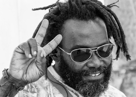 PORTO-NOVO, BENIN - MAR 10, 2012: Unidentified Beninese local man with dreads and sun glasses. People of Benin suffer of poverty due to the difficult economic situationのeditorial素材