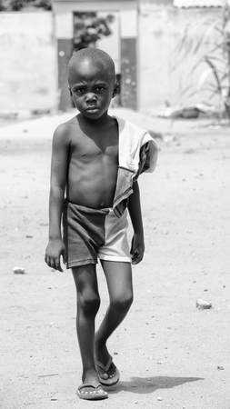 KARA, TOGO - MAR 9, 2013: Unidentified Togolese boy with sad eyes walks in the street. Children in Togo suffer of poverty due to the unstable econimic situationのeditorial素材