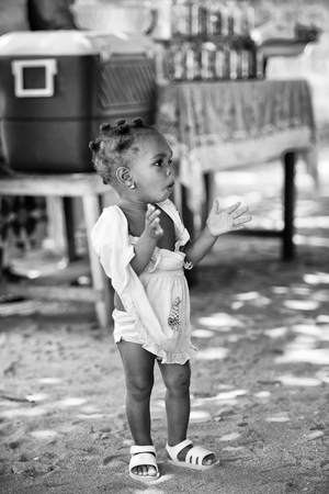 KARA, TOGO - MAR 9, 2013: Unidentified Togolese girl claps her hands in the street. Children in Togo suffer of poverty due to the unstable econimic situationのeditorial素材