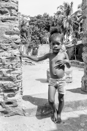 KARA, TOGO - MAR 9, 2013: Unidentified Togolese girl runs in the street. Children in Togo suffer of poverty due to the unstable econimic situationのeditorial素材