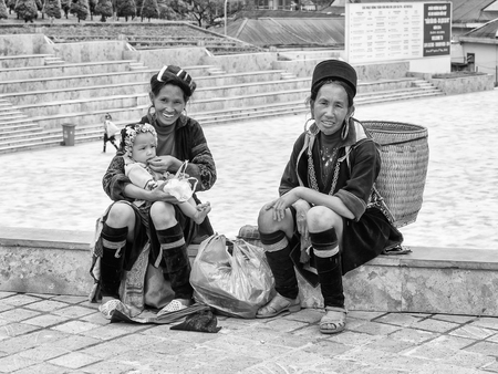 SAPA, VIETMAN - SEP 22, 2014: Unidentified Hmong woman in traditional dress a girl on the arms in Sapa, Vietnam. Hmong is a minority ethnic group of Vietnamのeditorial素材