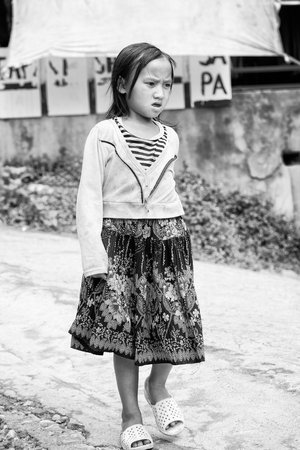 SAPA, VIETMAN - SEP 22, 2014: Unidentified Hmong girl walks in the street in Sapa, Vietnam. Hmong is a minority ethnic group of Vietnamのeditorial素材