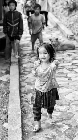 CATCAT VILLAGE, VIETMAN - SEP 12, 2014: Unidentified Vietnamese girl eats a candy in the Catcat village, Vietnam. 86 of Vietnamese people belong to the Viet ethnic groupのeditorial素材