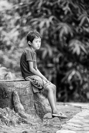 SAPA, VIETMAN - SEP 22, 2014: Unidentified Hmong boy sits and thinks in Sapa, Vietnam. Hmong is a minority ethnic group of Vietnamのeditorial素材