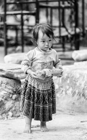 CATCAT VILLAGE, VIETMAN - SEP 12, 2014: Unidentified Vietnamese beautiful girl with an empty bottle in the Catcat village, Vietnam. 86 of Vietnamese people belong to the Viet ethnic groupのeditorial素材