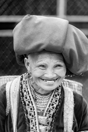 SAPA, VIETMAN - SEP 22, 2014: Unidentified Hmong woman in a traditional dress smiles with teethless mouth in Sapa, Vietnam. Hmong is a minority ethnic group of Vietnamのeditorial素材