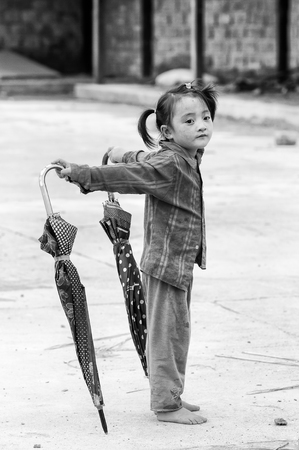 TA PHIN, VIETMAN - SEP 12, 2014: Unidentified Red Dao girl with an umbrella, Vietnam. Red Dao is a minority ethnic group of Vietnamのeditorial素材
