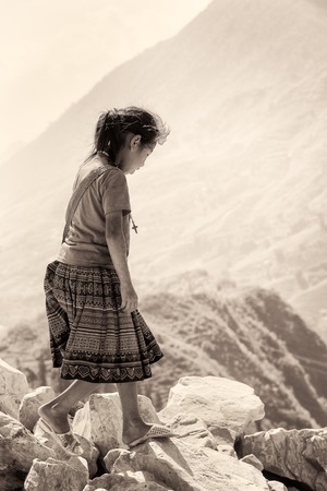SAPA, VIETMAN - SEP 12, 2014: Unidentified girl walks on the stones in Sapa, Vietnam. 86 of Vietnamese people belong to the Viet ethnic groupのeditorial素材